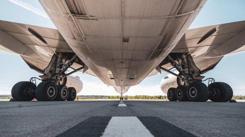 The underside of a commercial airliner looking at the landing gear.