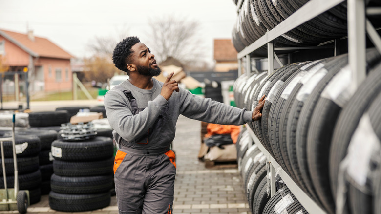 A person trying to choose a tire.