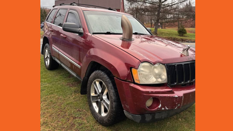 Red Jeep Grand Cherokee with massive exhaust out the hood