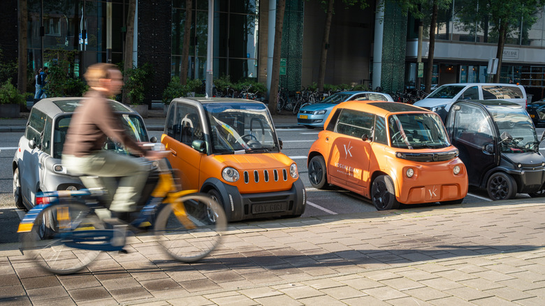 Biker passing microcars parked in Amsterdam financial district