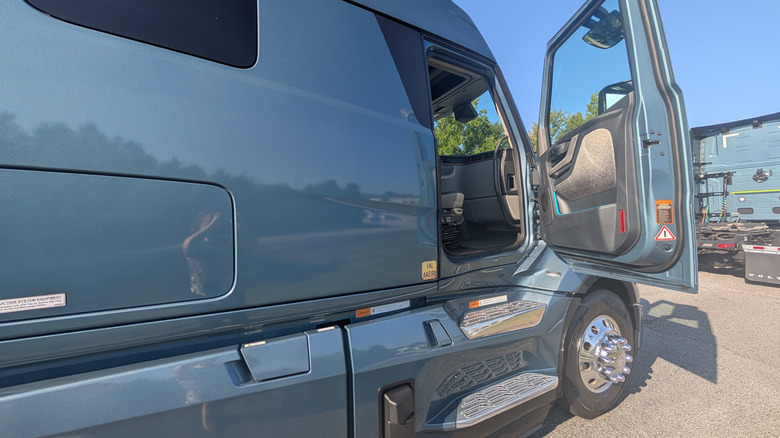 a blue Volvo VNL Semi truck parked at the Michelin Laurens Proving Grounds with it's door open on a sunny day