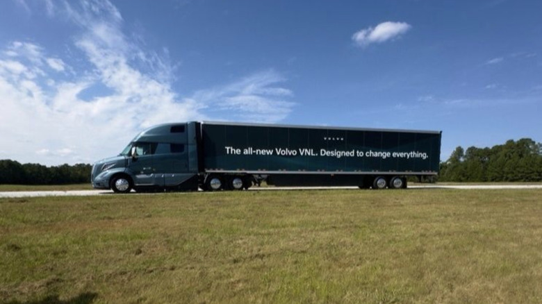 a blue Volvo VNL Semi truck in side profile parked at the Michelin Laurens Proving Grounds on a sunny day