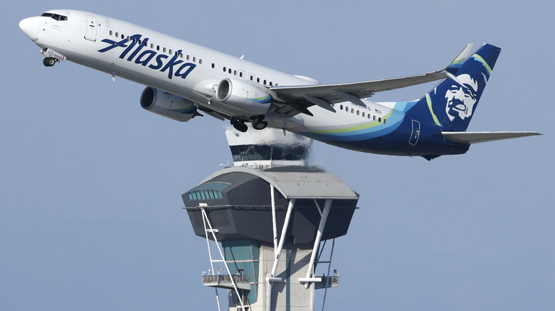 An Alaska Airlines Boeing 737 flies past the LAX ATC tower