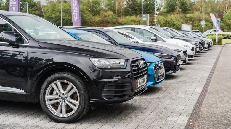 A row of used cars parked next to each other in a used car lot in the U.K.