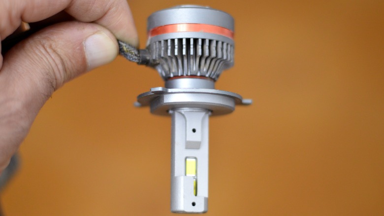 A man holding an aftermarket LED headlight bulb