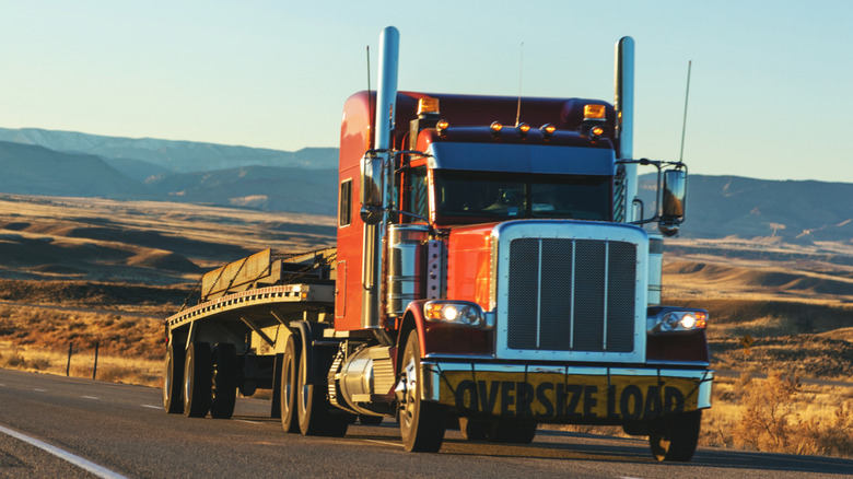 A semi truck hauling a load uphill in a desert
