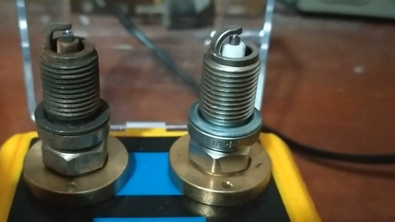 A socket style spark plug tester with two spark plugs inside it