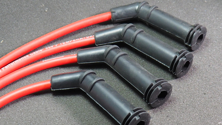 A group of red spark plug wires with black connecting boots