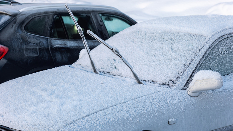 Car parked outdoors successful nan snowfall pinch raised wipers