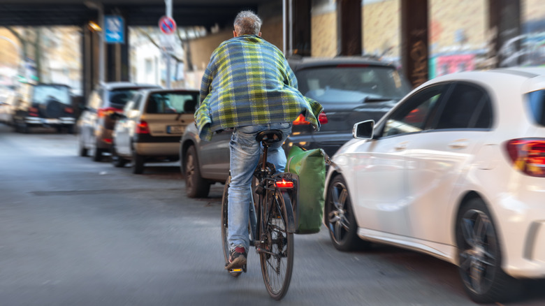A bike rider pedals a bike in an urban setting.