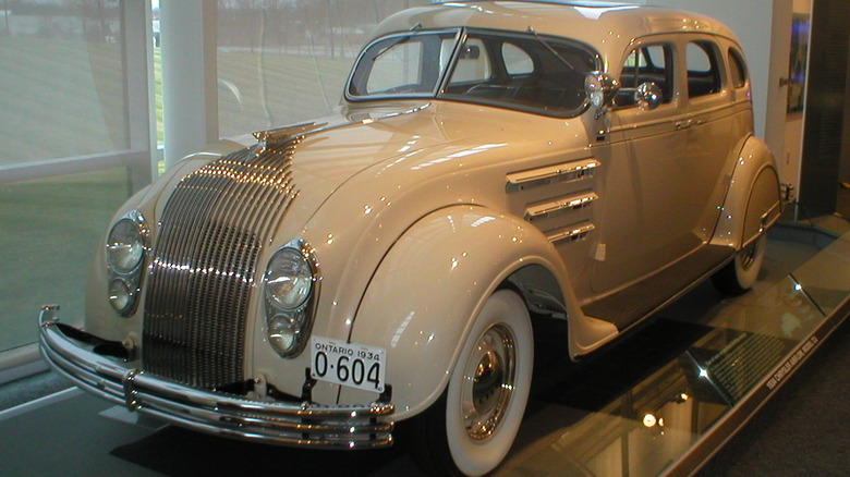A cream-colored 1934 Chrysler Airflow sits in a museum.