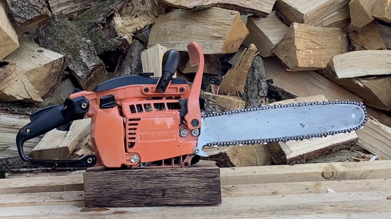 A Yanmar RH 350 S Wankel rotary engine chainsaw next to cut logs.