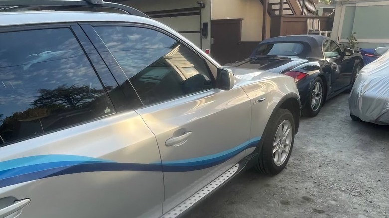 2005 BMW X3 parked in front of a Porsche Boxster