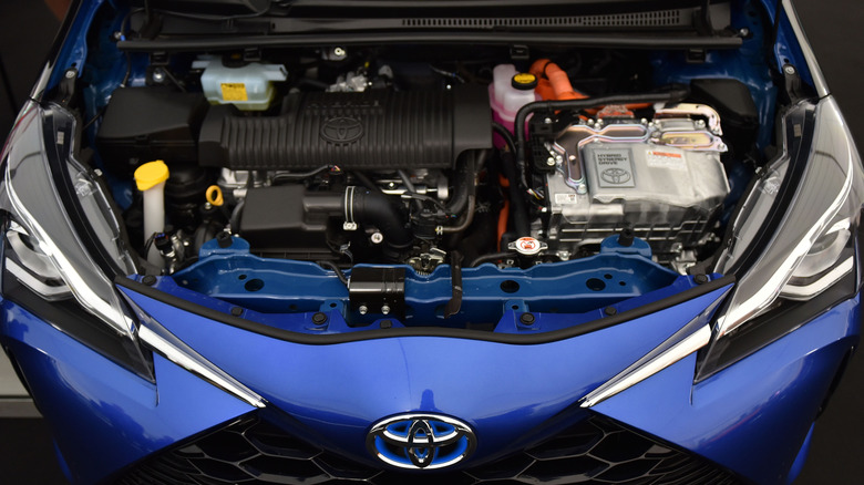 Blue Toyota with the engine visible under the hood.