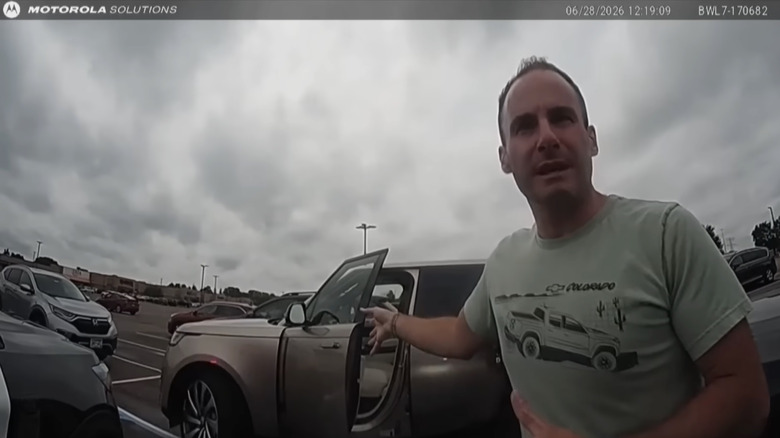 Joel Feder stands next to a Range Rover while stopped by police for an incorrect Flock camera hit on a "stolen" vehicle