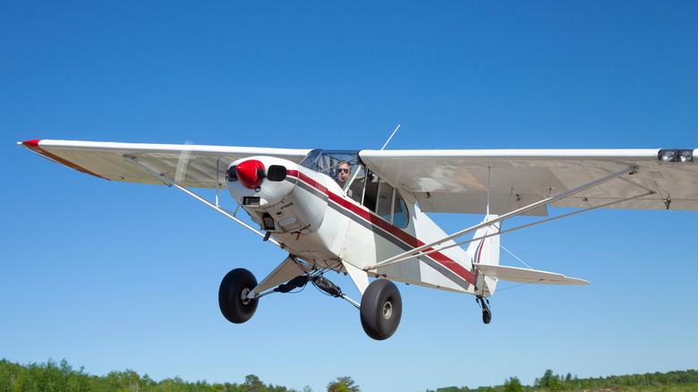 A small, single-engine piston airplane takes off from a Minnesota runway