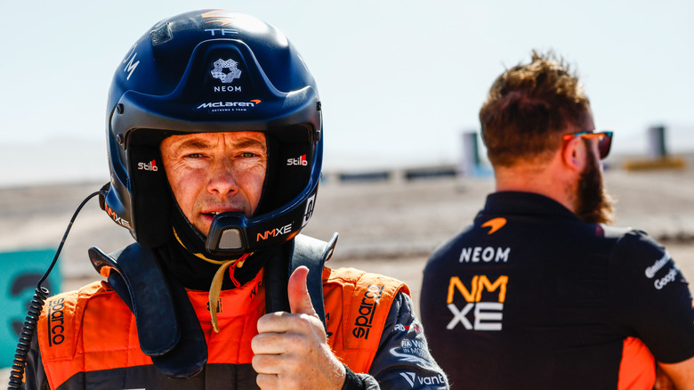 Tanner Foust in full racing gear giving a thumbs-up