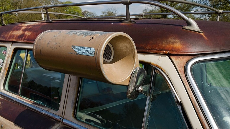 A 1954 Ford Country Squire Station Wagon with an air cooler in the right front window