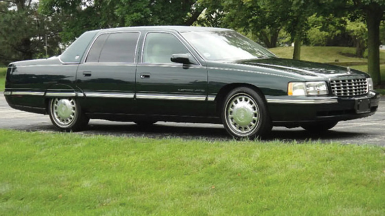 Dark green 1999 Cadillac Fleetwood Limited parked outside with grass and trees