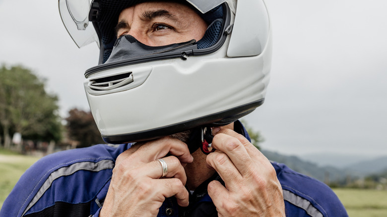Motorcyclist putting on a helmet