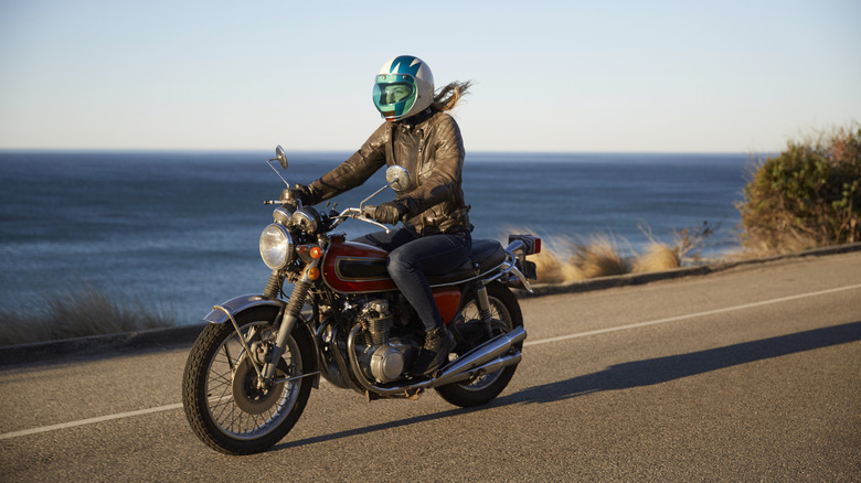 A motorcyclist riding along a coastline