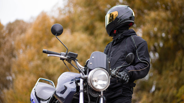 Motorcyclist in a motorcycle jacket and tinted helmet