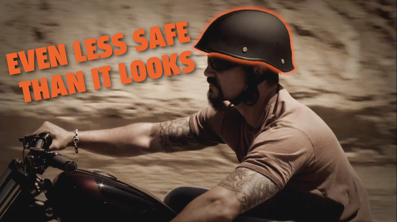 Rider on a cruiser with tattoos and a goatee in a half-helmet