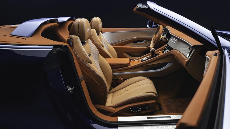 The interior of a blue Bentley Batur convertible with the door open