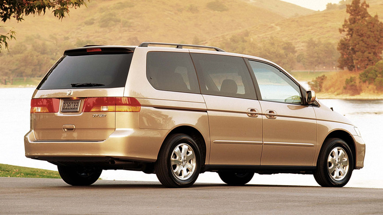 A Honda Odyssey sits parked by the water.