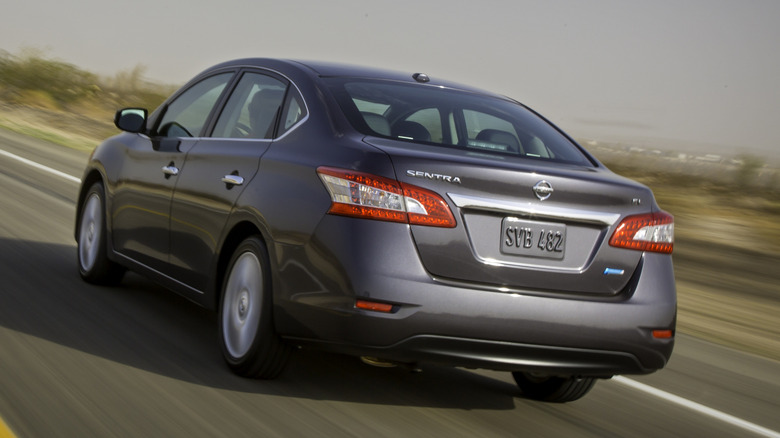 A grey Nissan Sentra drives on a highway.