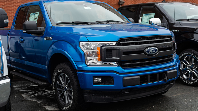 A blue Ford F-150 in a parking lot.