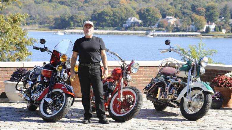 Billy Joel standing with three of his motorcycles