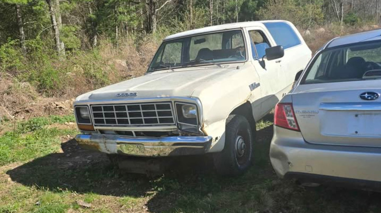 A white Dodge Ramcharger next to an Impreza