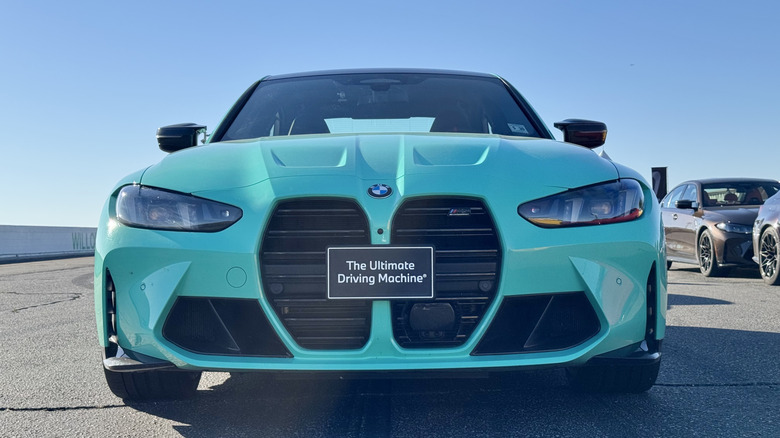 A close-up, head-on shot of the twin kidney grille of a turquoise M3