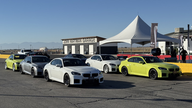 A shot of a group of M2s parked in the pits in front of a big tent and the John Hartman garage