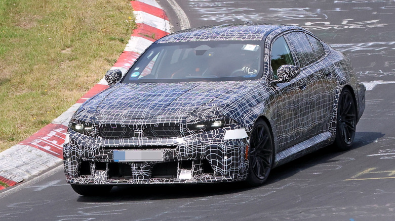 Front 3/4 view of a camouflaged BMW M5 prototype