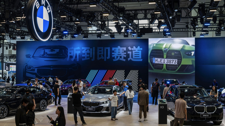 Attendees look at various models of BMW cars on display on the second media day at the Beijing International Auto Exhibition on April 25, 2026 in Beijing, China.