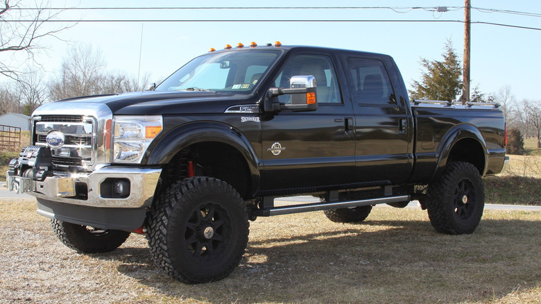 A black Ford pickup truck with raised suspenion.