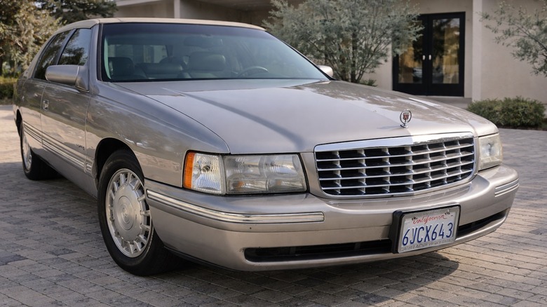 An AI-altered front 3/4 view of a 1999 Cadillac DeVille showing weird elements in the front license plate