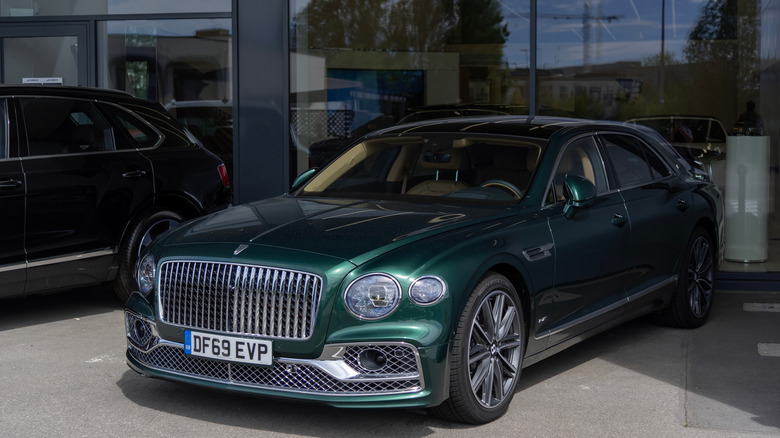 Bentley in British Racing Green parked by building