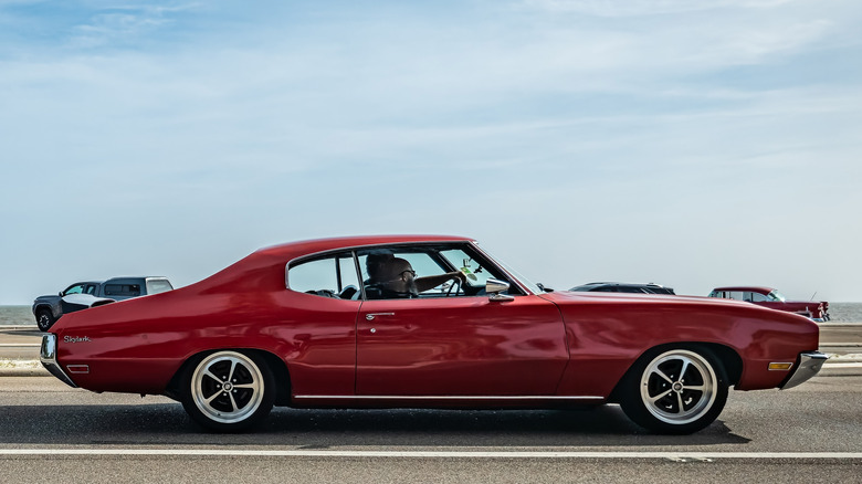 Side profile of a red 1972 Buick Skylark coupe with blue skies