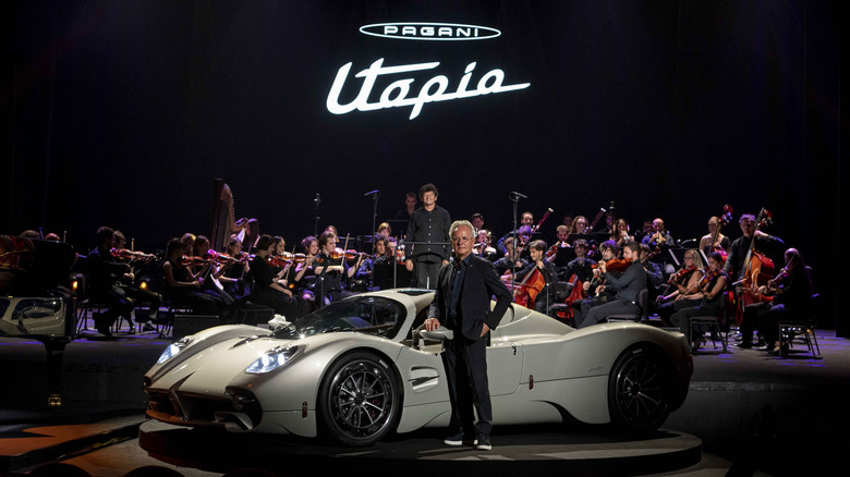 Horacio Pagani seen standing in front of a Utopia hypercar with an orchestra in the background
