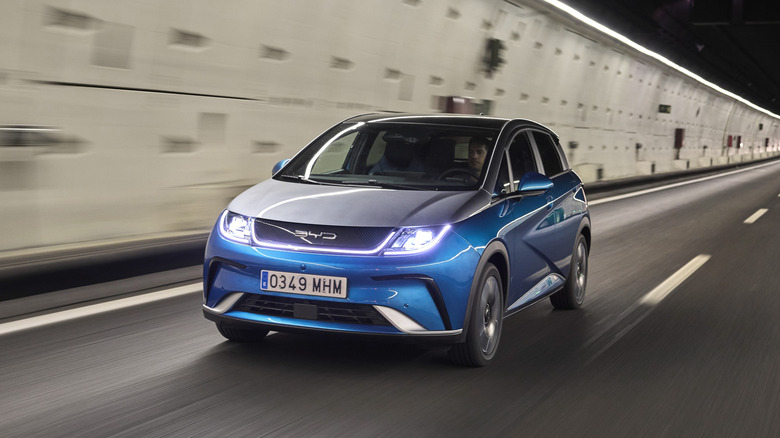 Blue BYD Dolphin City Surf hatchback left front three-quarter view seen driving in a tunnel