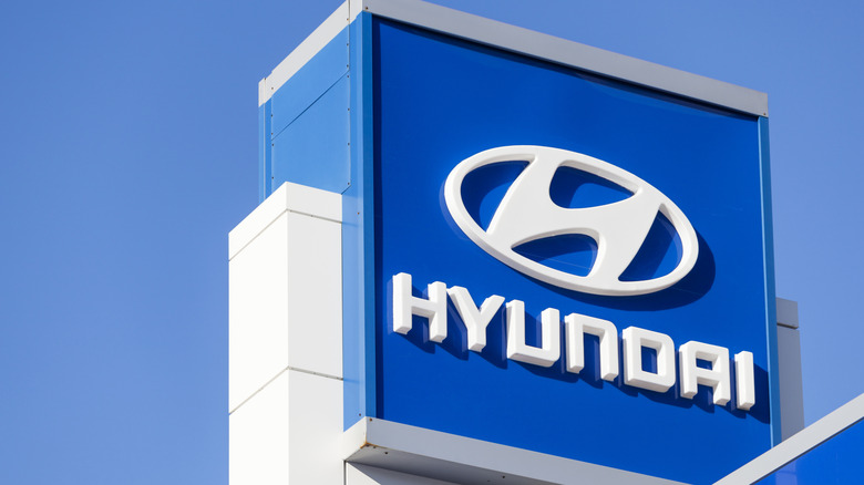 Halifax, Nova Scotia, Canada - December 11, 2011: Hyundai sign and logo above car dealership lot over building and showroom with clear, blue sky in background. Hyundai Motor Company was founded in 1967 and is known for producing the Hyundai Sonata, the Tuscani/Tiburon, the Sante Fe, the Tuscon, and the flagship Genesis Coupe and Sedan.