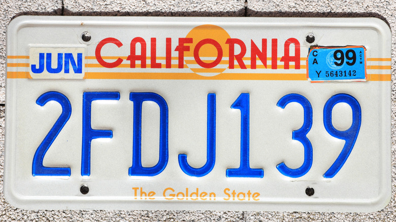 An older California license plate featuring the iconic sequence with 1999 tabs
