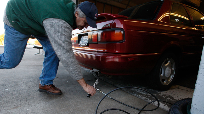 SAN RAFAEL, CA - DECEMBER 12: Alex Gromov puts a probe into the tailpipe of a car as he performs a smog check at Marinwood Smog Check December 12, 2007 in San Rafael, California. Federal District Judge Anthony W. Ishii upheld a 2002 California law that regulates greenhouse gas emissions from cars and trucks, a move that would force automakers to increase the average fuel economy of their fleets by about 30 percent by 2016. A similar bill that is pending in Congress would require a 40 percent mileage increase by 2020. (Photo by Justin Sullivan/Getty Images)