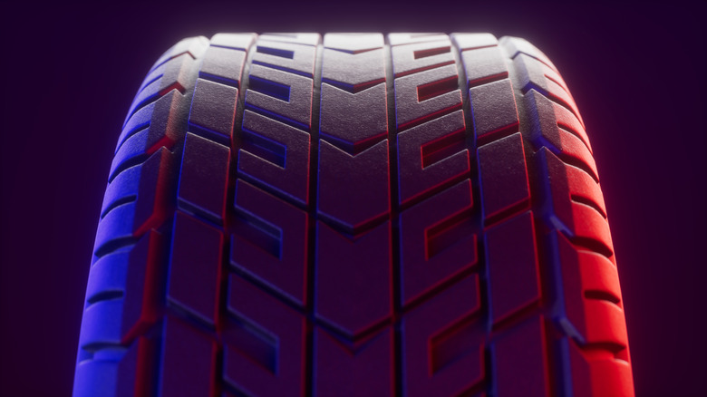 Close-up of a tire's tread, lit red on the right and blue on the left