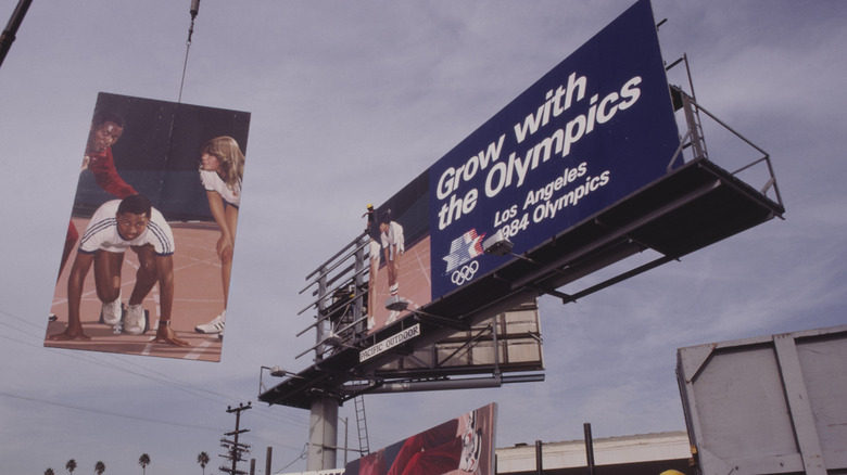 A billboard with the slogan 'Grow With The Olympics, Los Angeles 1984 Olympics' being raised into position during the 1984 Summer Olympics, in Los Angeles, California, 1984. The 1984 Games ran from 28th July to 12th August. (Photo by Michael Montfort/Michael Ochs Archives/Getty Images)
