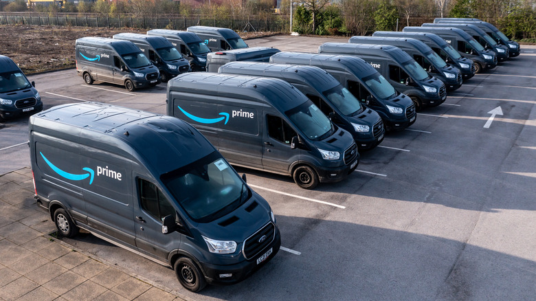 A row of Amazon Prime E-Transit vans in a parking lot