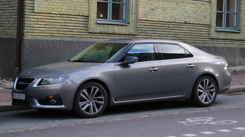 A grey street-parked 2011 Saab 9-5.